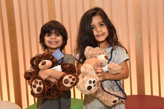 two kids with golden teddy bears